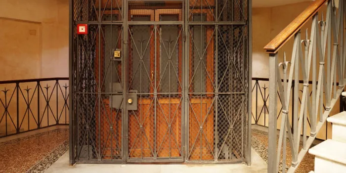 vieux ascenseur en bois dans un puits de métal