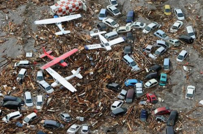 Avions et voitures recouverts de débris à l'aéroport de Sendai