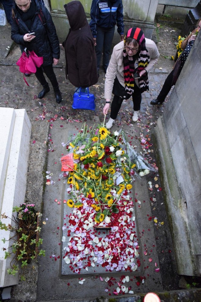 Une fan déposant une fleur sur la sépulture de l'artiste 
