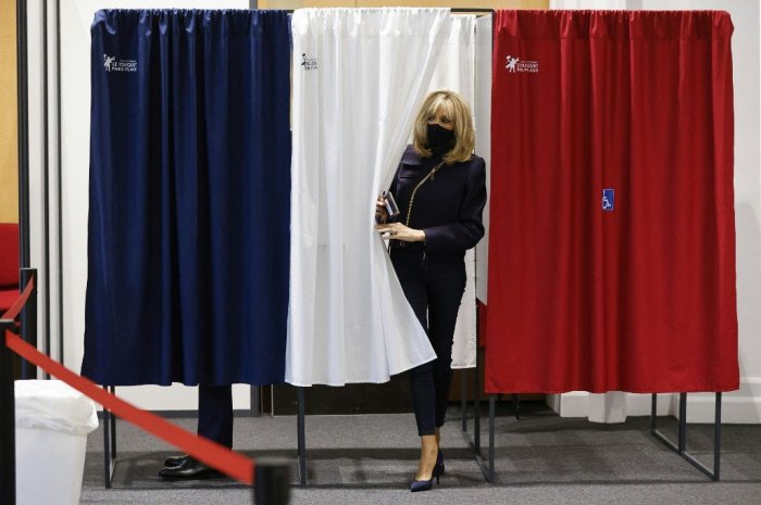 Brigitte Macron sort d'un isoloir lors du second tour des élections régionales