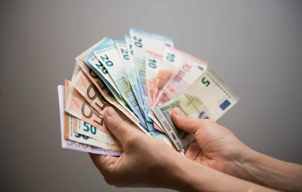 Hands holding euro banknotes