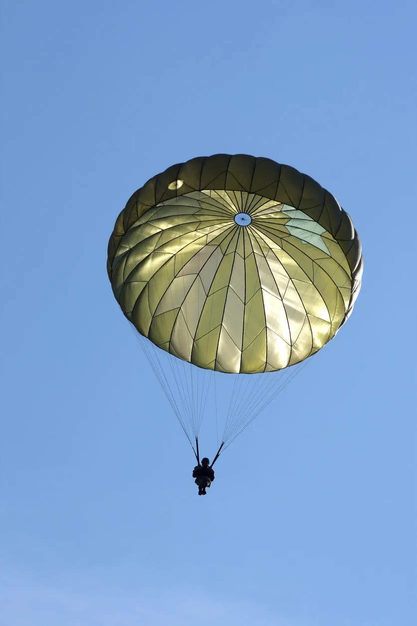 parachutiste lors d'un exercice militaire avec un ciel bleu derrière