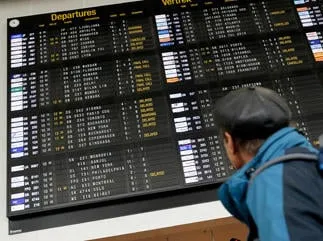 une personne vérifie le tableau des départs lors d'une grève du service sol et fret de swissport à l'aéroport national de bruxelles à zaventem, le 12 mai 2013 afp photo virginie lefour