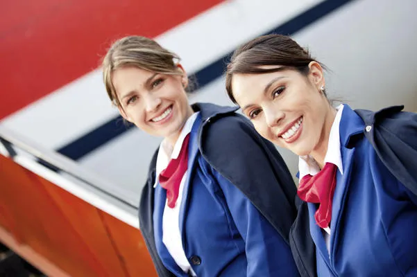 hôtesses de l'air amicales souriant et accueillant dans l'avion