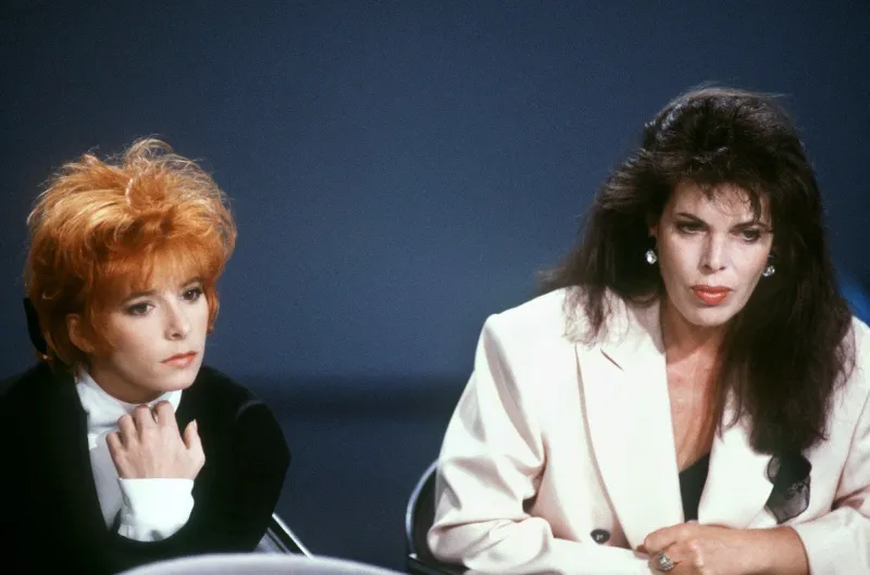 les chanteuses françaises mylene farmer (g) et dani participent à l'émission sida   le grand rendez-vous présentée par jean-marie cavada, le 04 juin 1987, sur le plateau d'antenne (france 2) à paris (photo by georges bendrihem   afp)