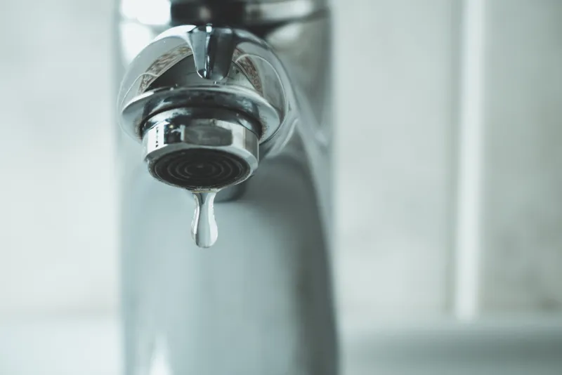 water drop dripping from the tap and water shortage