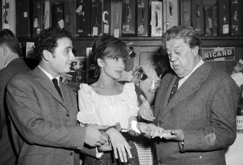 les acteurs claude brasseur (g) et michel simon (d) passent les menottes à l'actrice dany saval en clin d'oeil à leur dernier film pierrot la tendresse, qui vient de sortir, à paris, le 11 novembre 1960 afp photo (photo by upi   afp)