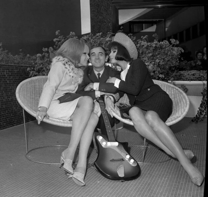 picture of french singer and songwriter charles aznavour (c) with dany saval (l) and dominique boschero (r) on the set of the film cherchez l'idole, directed by michel boisrond, in the maison de la radio, in paris, 09 october 1963 (photo by afp)