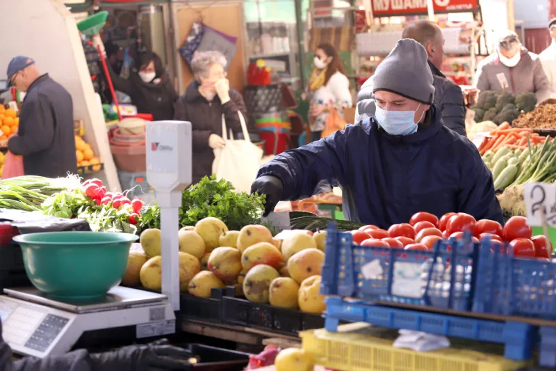people, with face masks for protection, are shopping vegetables and fruits at marketplace in sofia, bulgaria - march 17