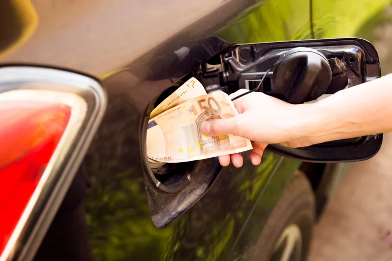 transportation expenses concept - euro money in car fuel tank