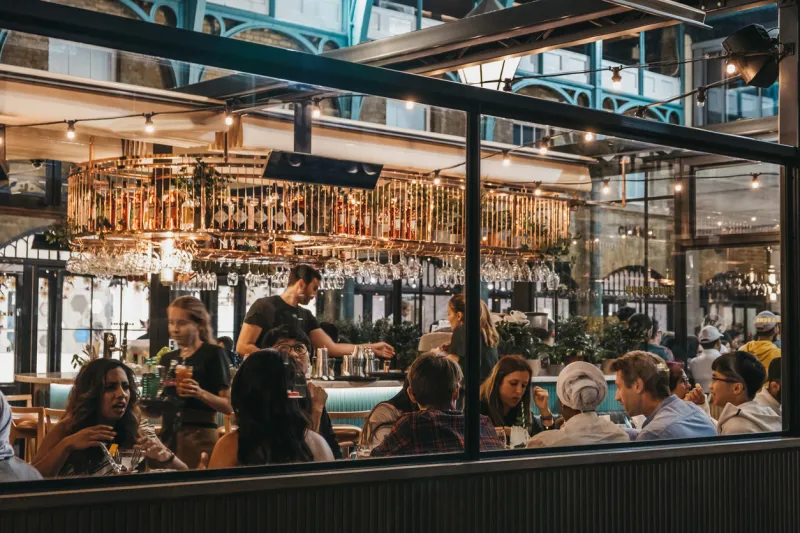 london, uk - august 31, 2019  view through the window of staff and customers inside buns and buns restaurant in covent garden market, one of the most popular tourist sites in london, uk