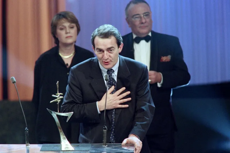 french journalist jean-pierre pernaut (c) speaks after receiving the 7 d'or television award from french journalists yves mourousi and marie-laure augry at the palais des sports in paris on january 27, 1997 (photo by patrick kovarik   afp)