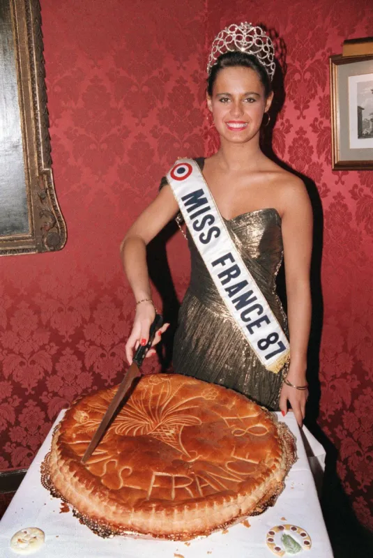 miss alsace, nathalie marquet, proclamée miss france 1987 dans la nuit de la saint-sylvestre, découpe une énorme galette des rois, le 03 janvier 1987, dans un grand restaurant parisien(film)  michel clement afp photo (photo by michel clement   afp)