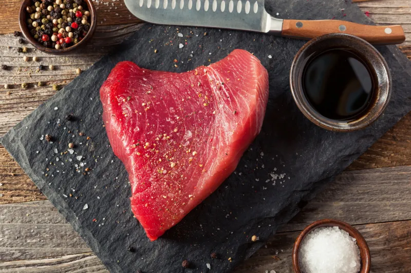 raw organic pink tuna steak with salt and pepper