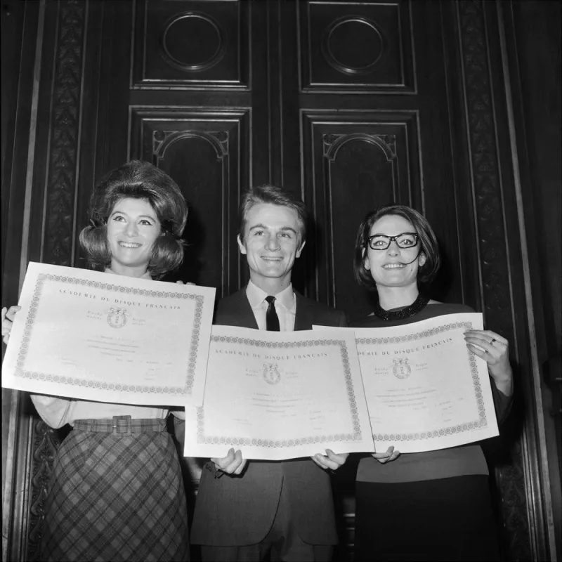 picture released on november 22, 1963 of french singers sheila (l), claude françois (c) and greek singer nana mouskouri (r) holding their awards of the academy of the french record, at the hotel de ville of paris (photo by afp)