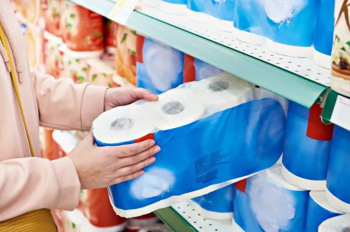 toilet paper in the hands of the buyer in the store