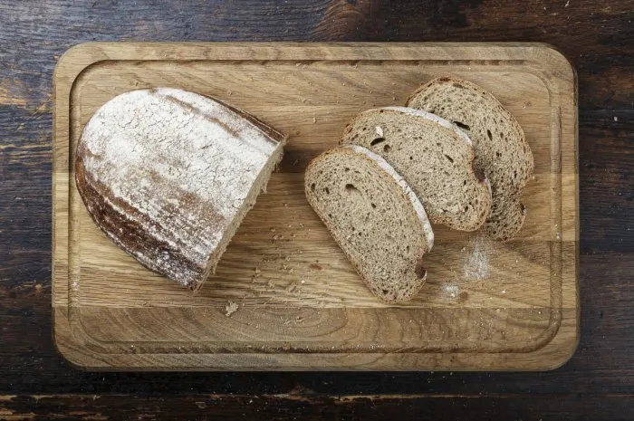 sliced fresh rye bread on a brown wooden background simple rustic background