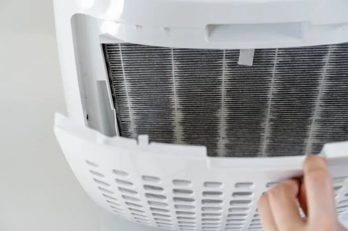 focused on dirty filter asian woman changing the dirty air purifier filter after using for a long time in the dirty air environment using air purifier clean the air for better atmosphere in a house
