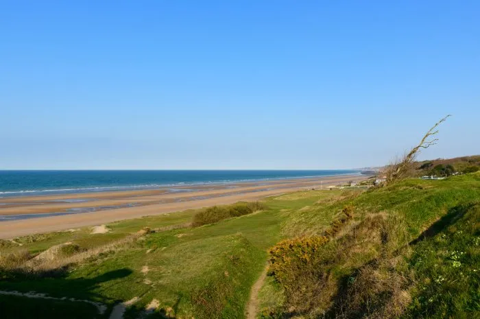 this landscape photo was taken in europe, in france, in normandy, towards arromanches, in colleville, in the spring we see the beach of the overlord landing of omaha beach seen from the steep cliffs, under the sun