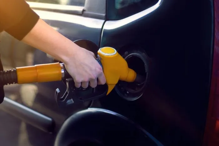 the girl at the gas station with a hose in her hand and fills the car with gasoline