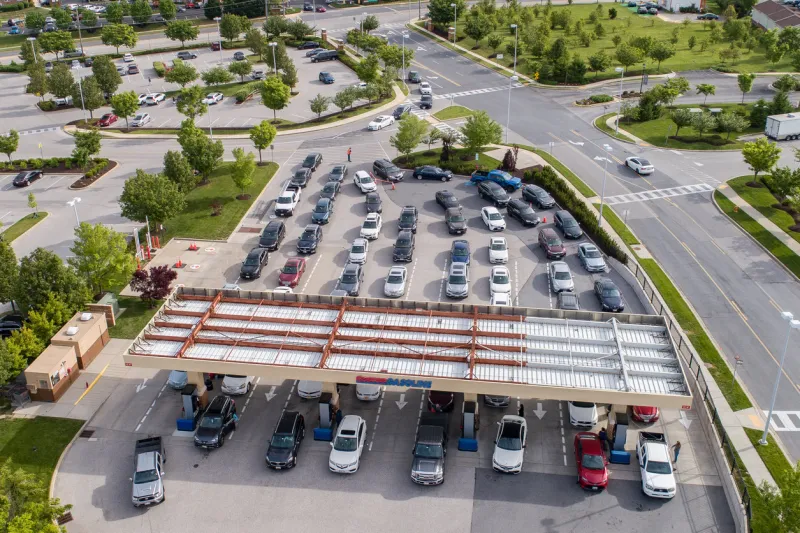 aerial high-angle view of cars lined up for gas in the morning at a gas station during the perceived gas shortage