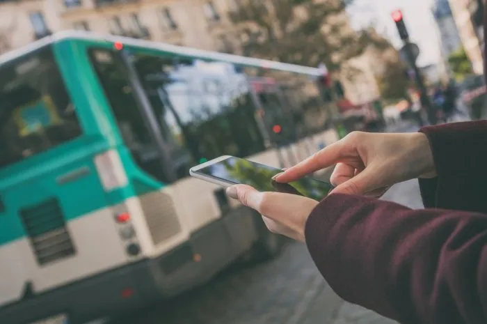 woman using cellphone and crossing the street