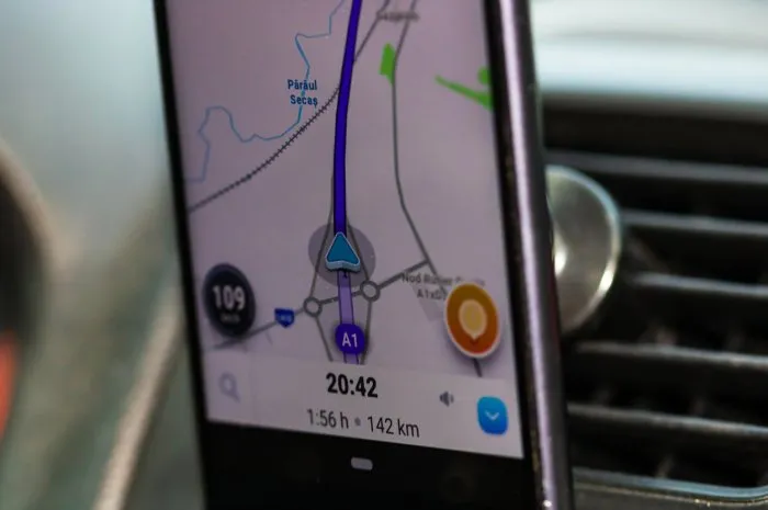 using waze maps application on smartphone on car dashboard, close up of application bucharest, romania