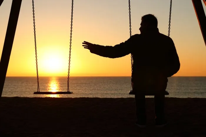 man alone missing her partner at sunset