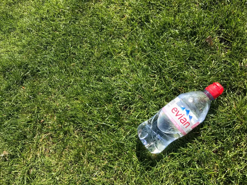iasi, romania - april 10, 2017  bottle of evian water on the green grass