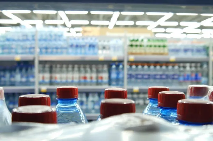 close-up of many bottles of water with red caps on a store shelf