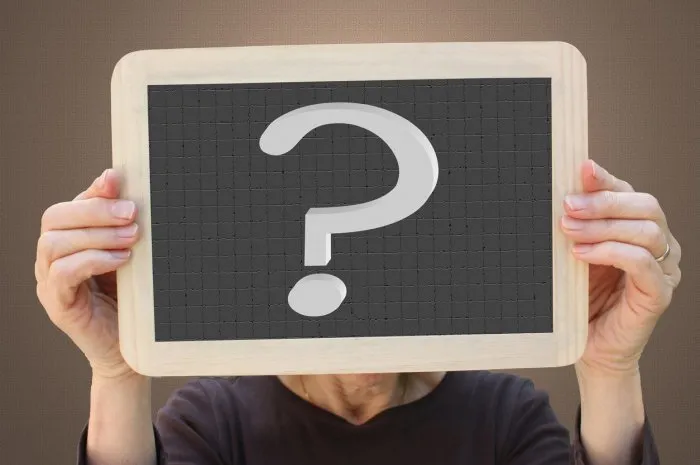 woman carrying a sign with a question mark