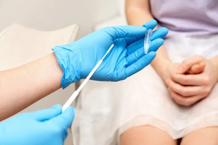the gynecologist takes a sample of biomaterial from the patient's urogenital tract for pcr examination,hands close- upwomen's health, medical concept