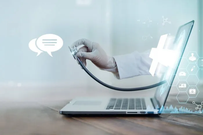 virtual doctor concept, the doctor's hand with stethoscope protrudes from the laptop screen to examine the patient online consultation, virtual hospital and online therapy