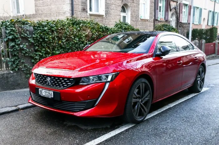 bern, switzerland - march 13, 2019  red motor car peugeot 508 in the city street