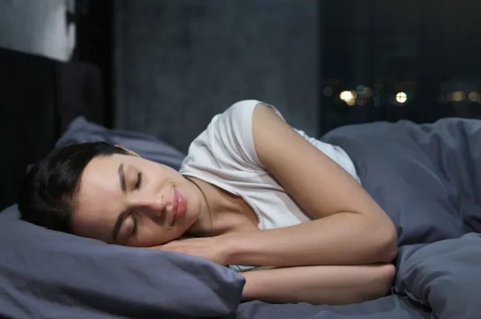 young female sleeping peacefully in her bedroom at night, relaxing