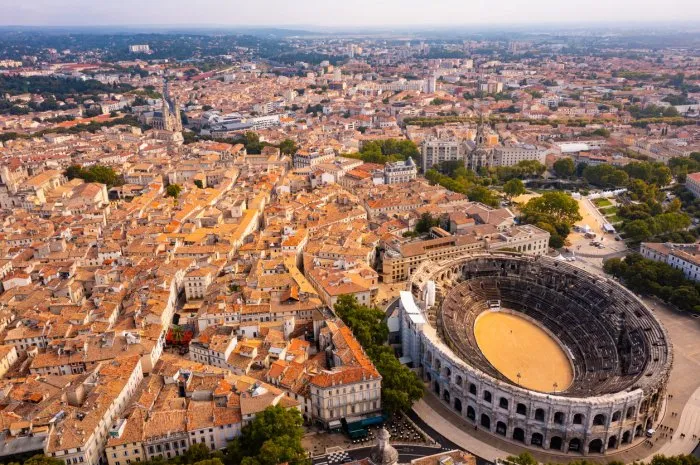 aerial view of historical area of french city of nimes overlooking restored antique roman amphitheatre on sunny autumn day