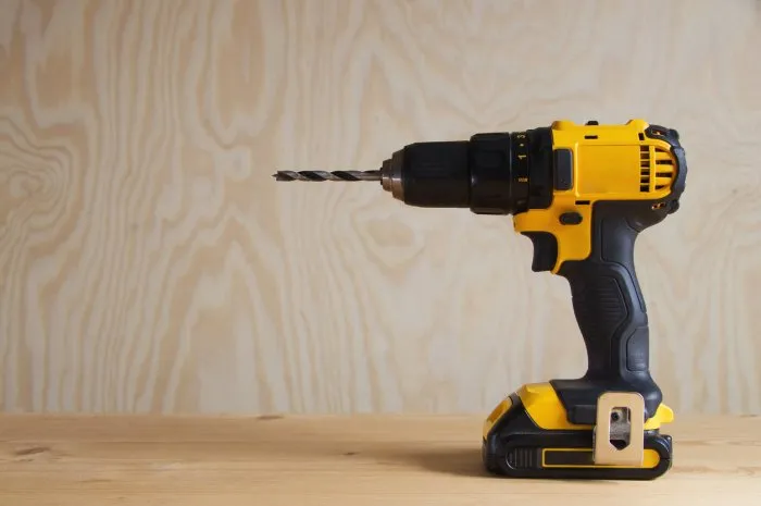 cordless drill against wooden background, rechargeable drill