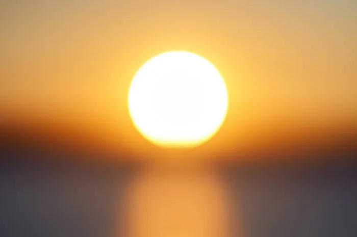 blur big bright orange sunny disk at sunset of day in the sky close-up beautiful bokeh background for your ideas and design