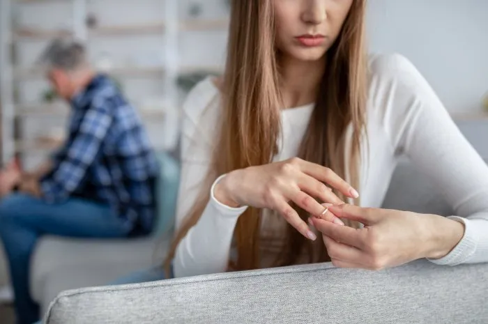 gray divorce concept cropped view of middle-aged woman taking off wedding ring, thinking about breakup with her husband at home, copy space mature couple getting late-in-life separation
