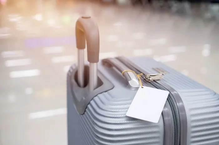 luggage holder tag blank label on suitcase   baggage put letter travel insurance word for display your products near combination locks for traveling luggages in airport terminal, copy space for text