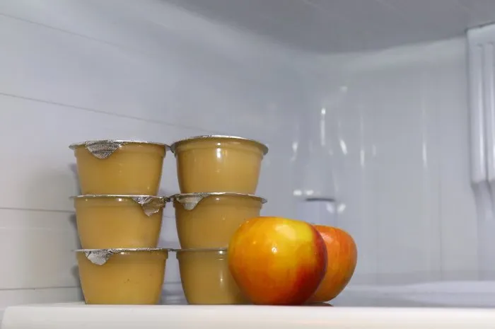individual containers of applesauce inside of a fridge