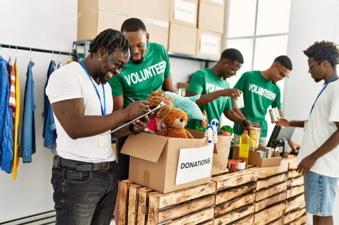 group of young african american volunteers working at charity center