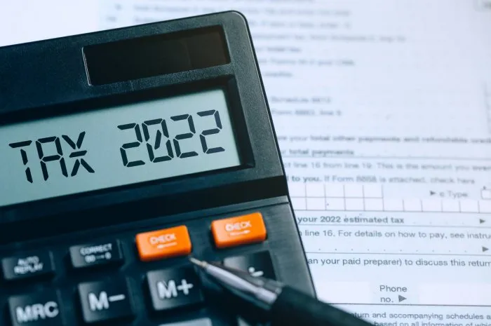 word tax 2022 on the calculator on documentsincome statement paying the tax rate taxation, taxes burdenbusiness and tax concept