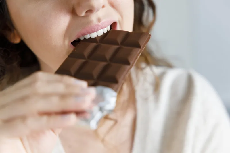 young woman eating chocolate at home