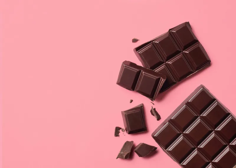 dark chocolate on pink background top view