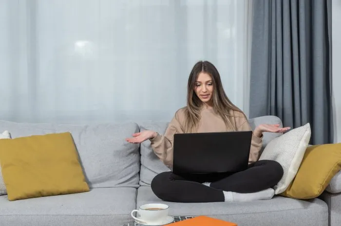young teenage girl sitting on sofa at home arguing with her boyfriend on video call on laptop computer angry frustrated young woman have fight over web cam with her fiance