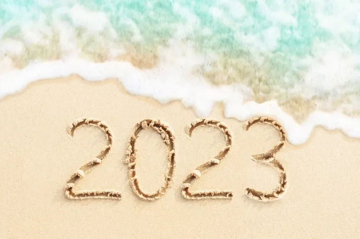 soft ocean wave on sand background year number 2023 handwritten on sand