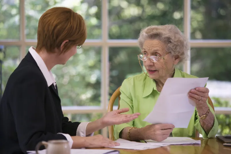 mature woman talking to financial planner at home