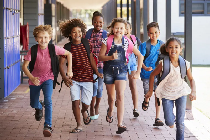 school kids running in elementary school hallway, front view