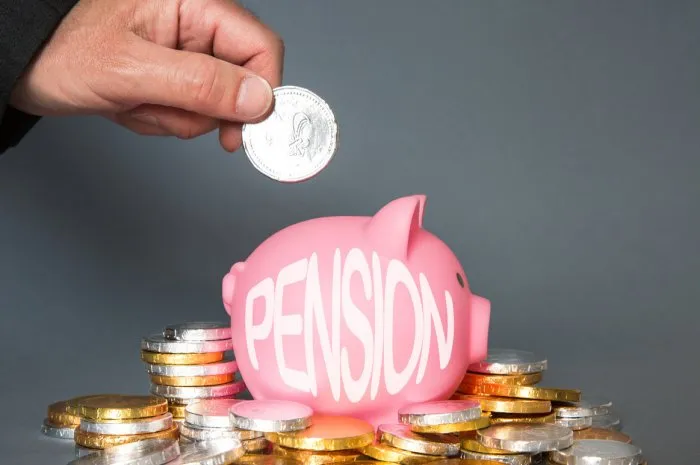 a pension or retirement concept of an employee, employer or person adding and contributing money to a pension scheme with copy space